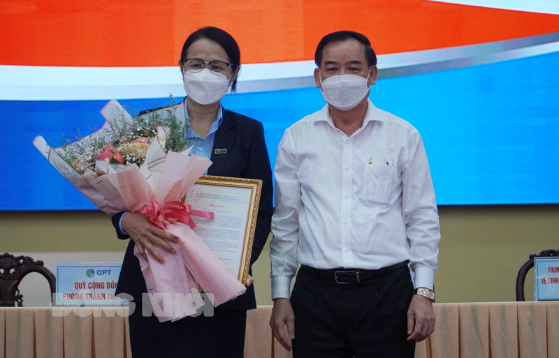 Chủ tịch UBND tỉnh Trần Ngọc Tam trao hoa cho lãnh đạo Quỹ Cộng đồng phòng chống thiên tai.
